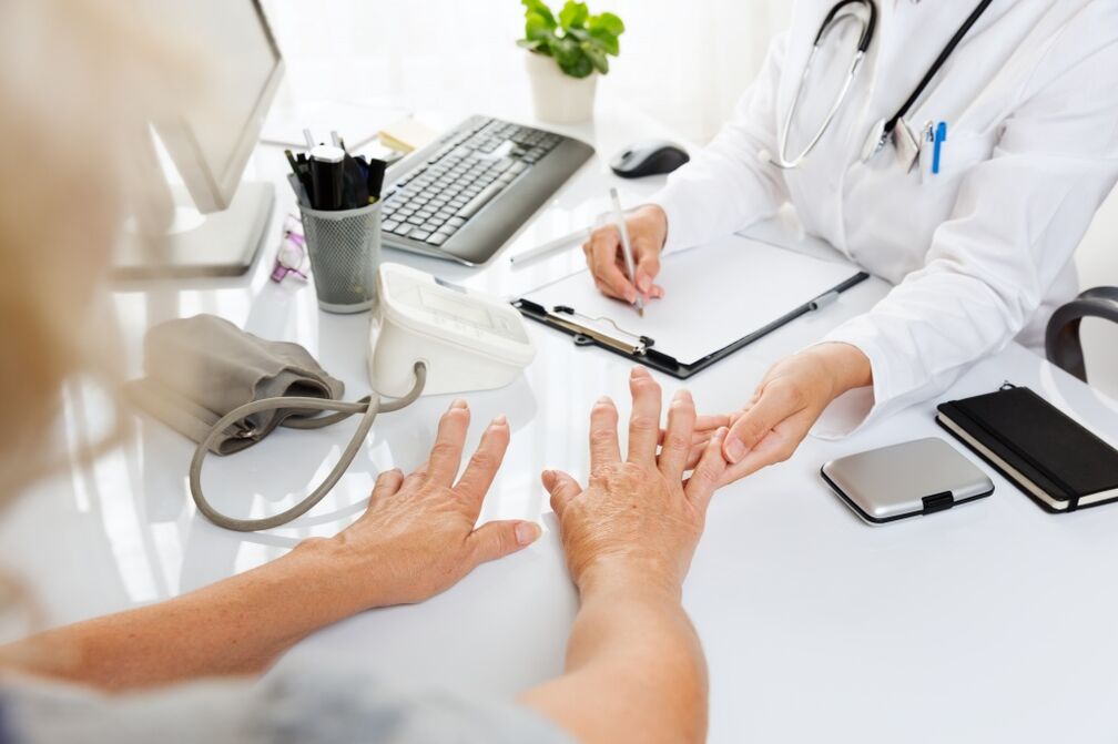 medicul examinează mâinile cu artroză